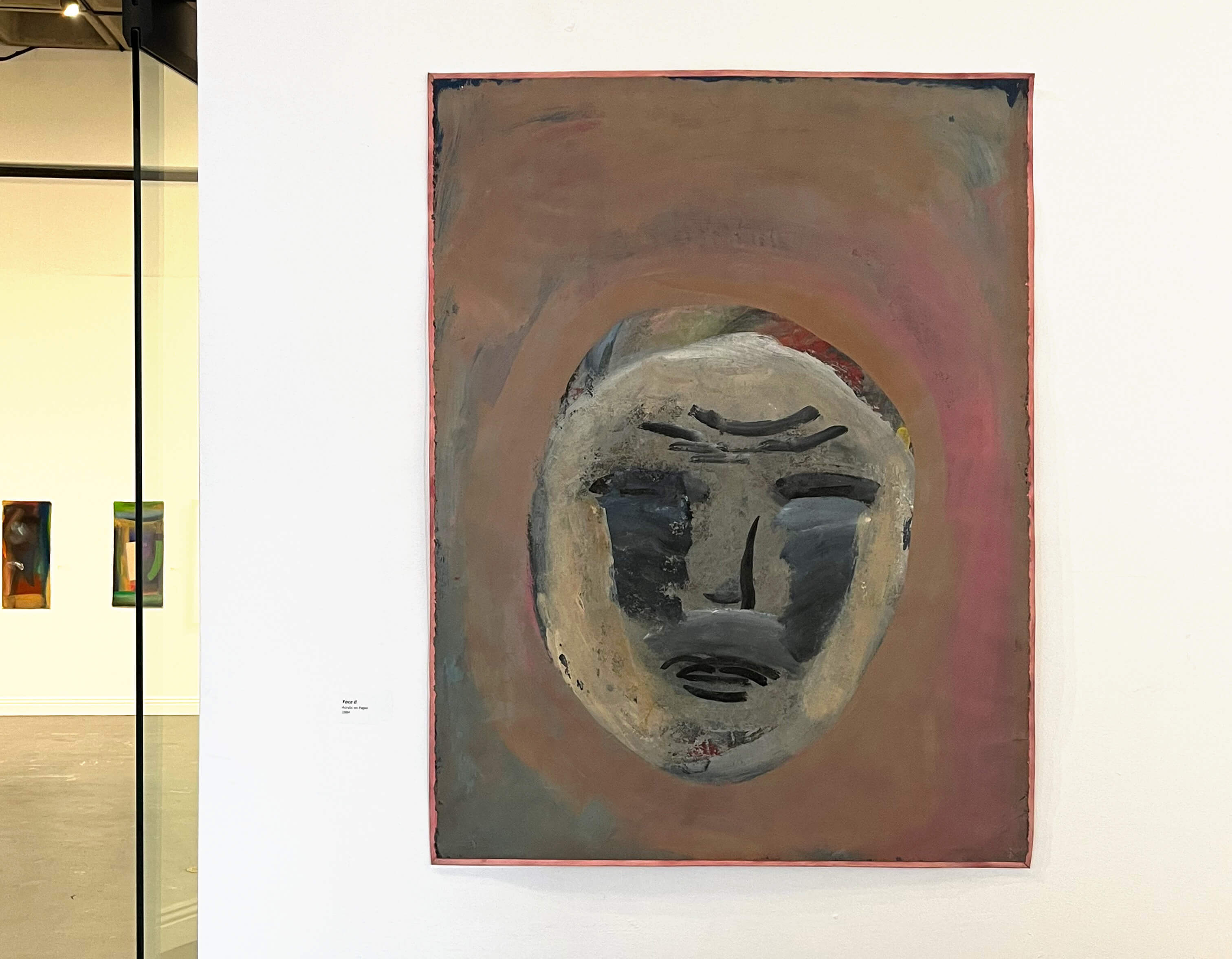 Installation view, Keisho Okayama: Selected Works - Face II, acrylic on paper, 1984, at the entrance to the exhibition.